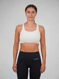 Kvinna i beige Ambitious Sports Bra från Humble Athletics